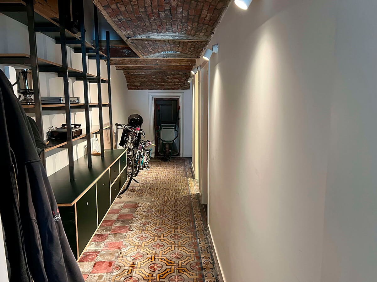 Hallway providing access to both workspace rooms in the basement